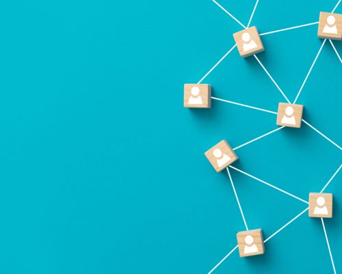 Teamwork, network and community concept. Wooden blocks connected together on blue background. Teamwork, network and community concept.
